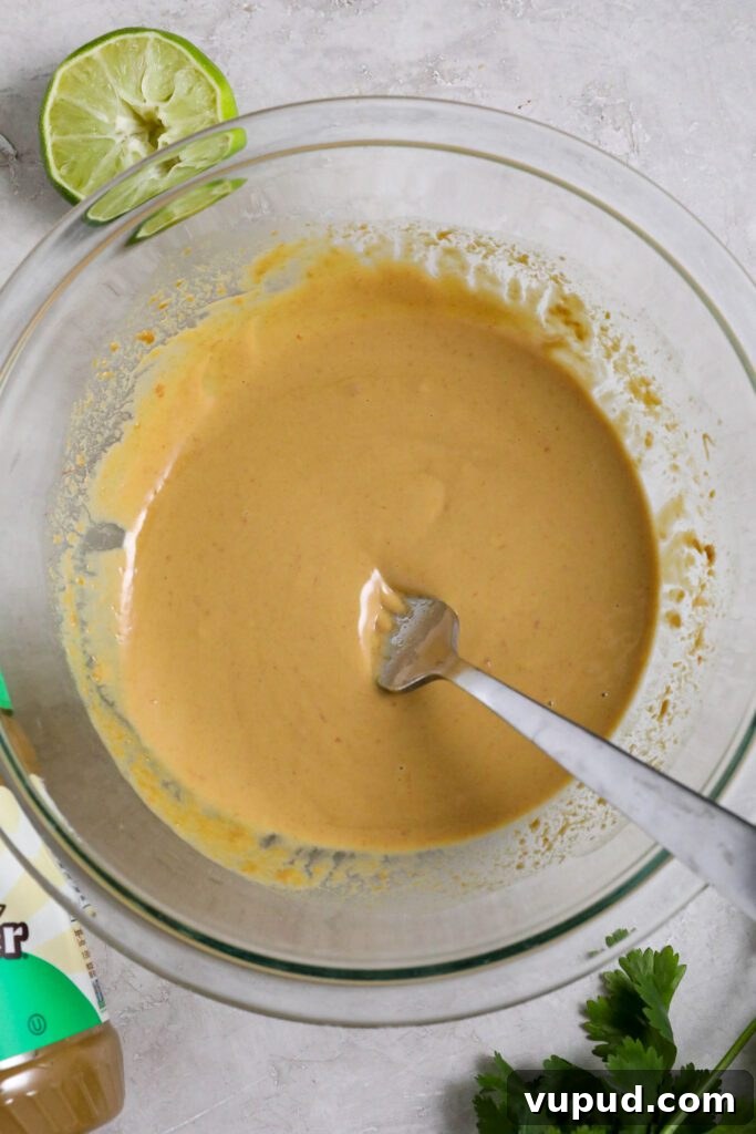 SunButter Peanut Butter Ramen Bowls: Creamy Savory Noodle Recipe 4 SunButter sauce mixed in glass bowl with lime and cilantro by Flora & Vino