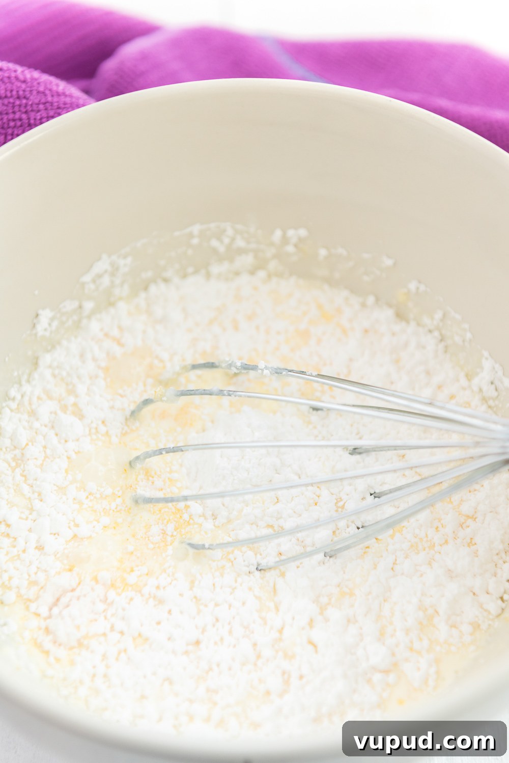 Boston Cream Donuts: Where to Find & How They're Made in Boston 6 Heavy cream, sugar, and other pastry cream ingredients being mixed in a white bowl.