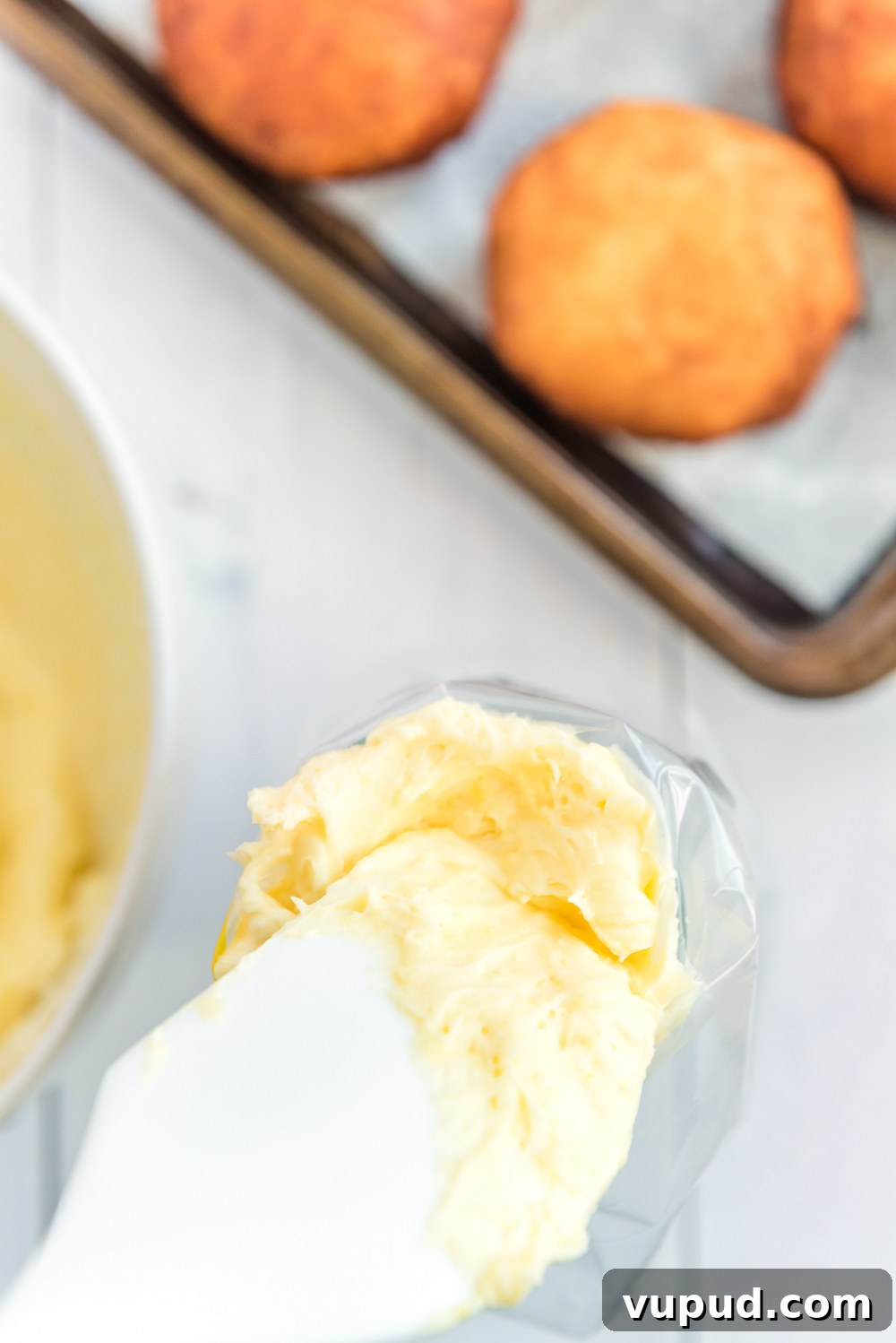 Boston Cream Donuts: Where to Find & How They're Made in Boston 7 Pastry cream being added to a plastic piping bag with a white rubber spatula.