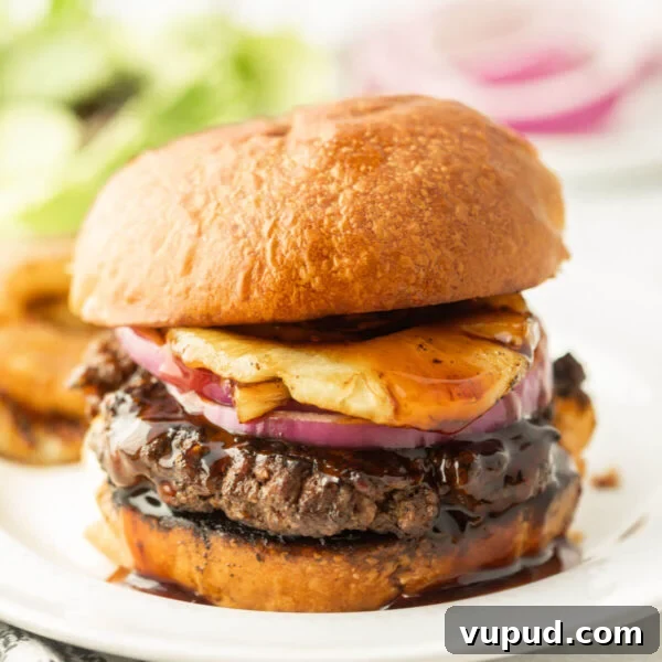 Crispy Pineapple Chicken on the Blackstone Grill: Sweet & Savory Recipe 13 Beef burger with beef patty, cheese, onions, and barbecue sauce on a plate.