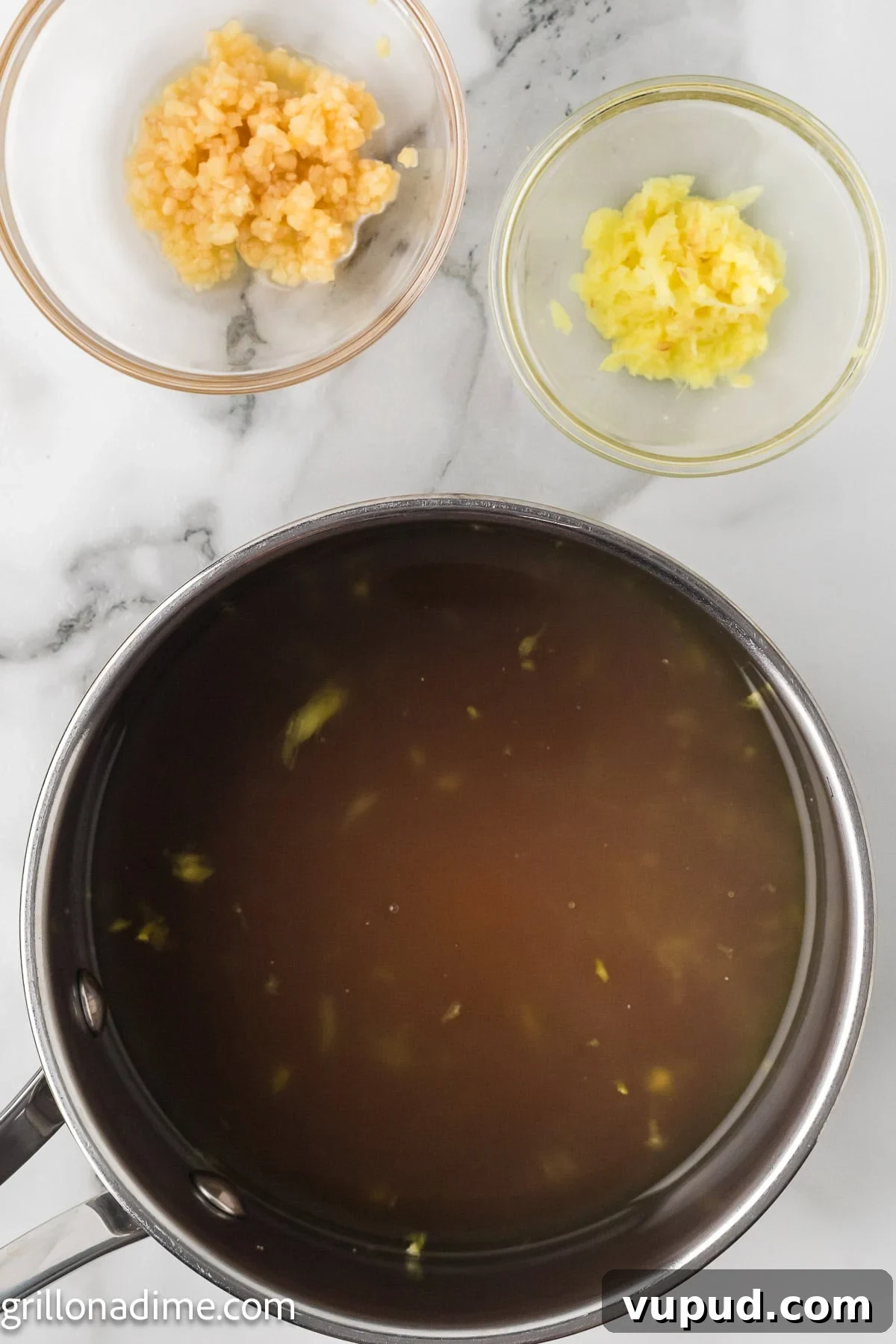 Crispy Pineapple Chicken on the Blackstone Grill: Sweet & Savory Recipe 7 A large pot combined with soy sauce, honey and pineapple juice. With two bowls of minced garlic and pineapple pieces