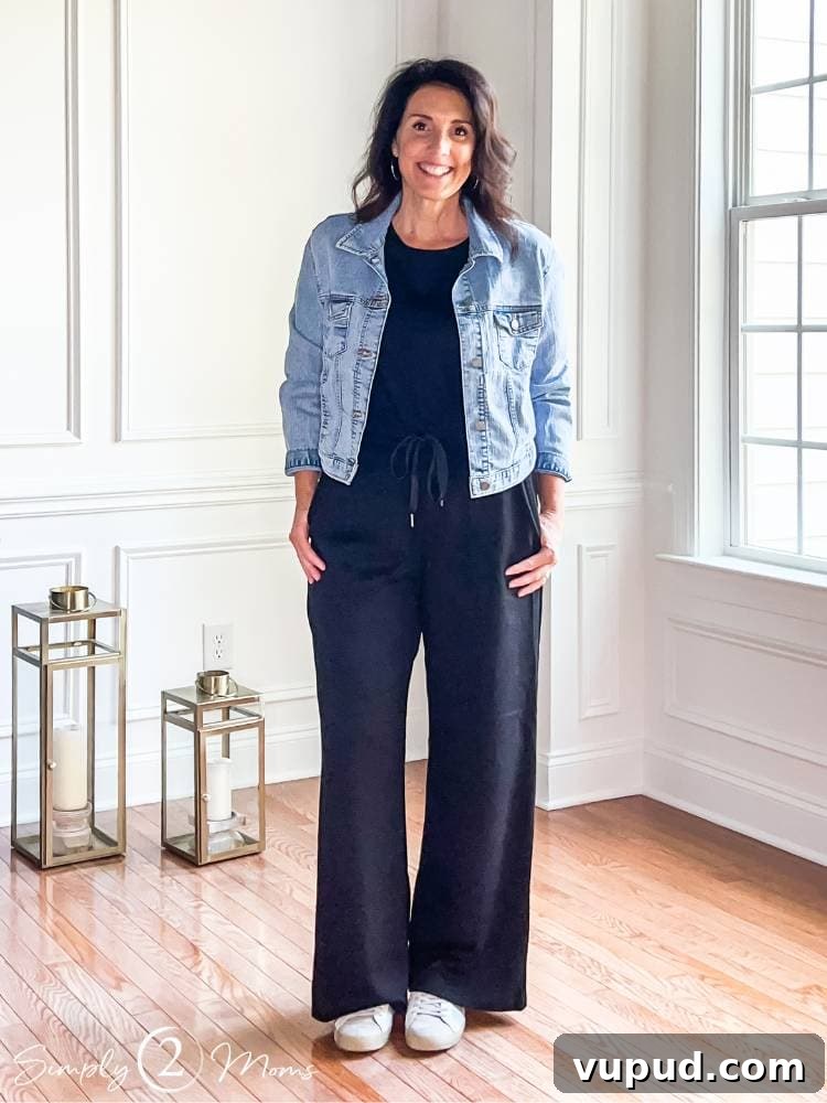 AnnMarie wearing wide leg black one piece jumpsuit with jean jacket and sneakers