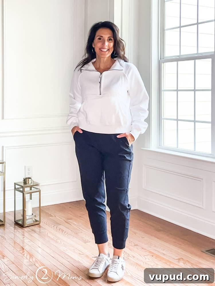 AnnMarie wearing white half zip top with black joggers standing indoors