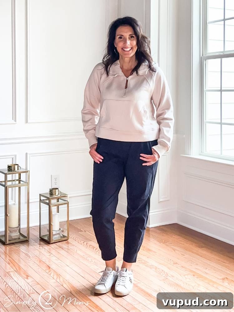 AnnMarie posing in travel outfit in dining room. Black pants and tan sweatshirt
