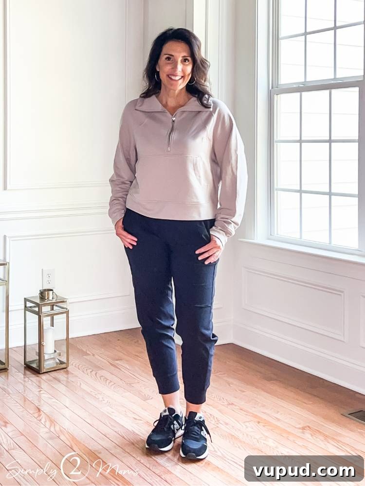 woman wearing travel outfit including black joggers and cropped sweatshirt