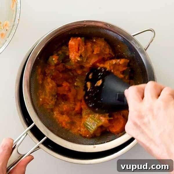 Spatchcock Turkey with Gluten-Free Gravy Cooked in HexClad Pan 16 Straining the vegetables into the gravy.