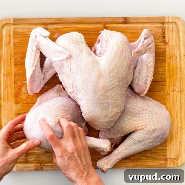 Spatchcock Turkey with Gluten-Free Gravy Cooked in HexClad Pan 6 Cutting the turkey legs from the body.