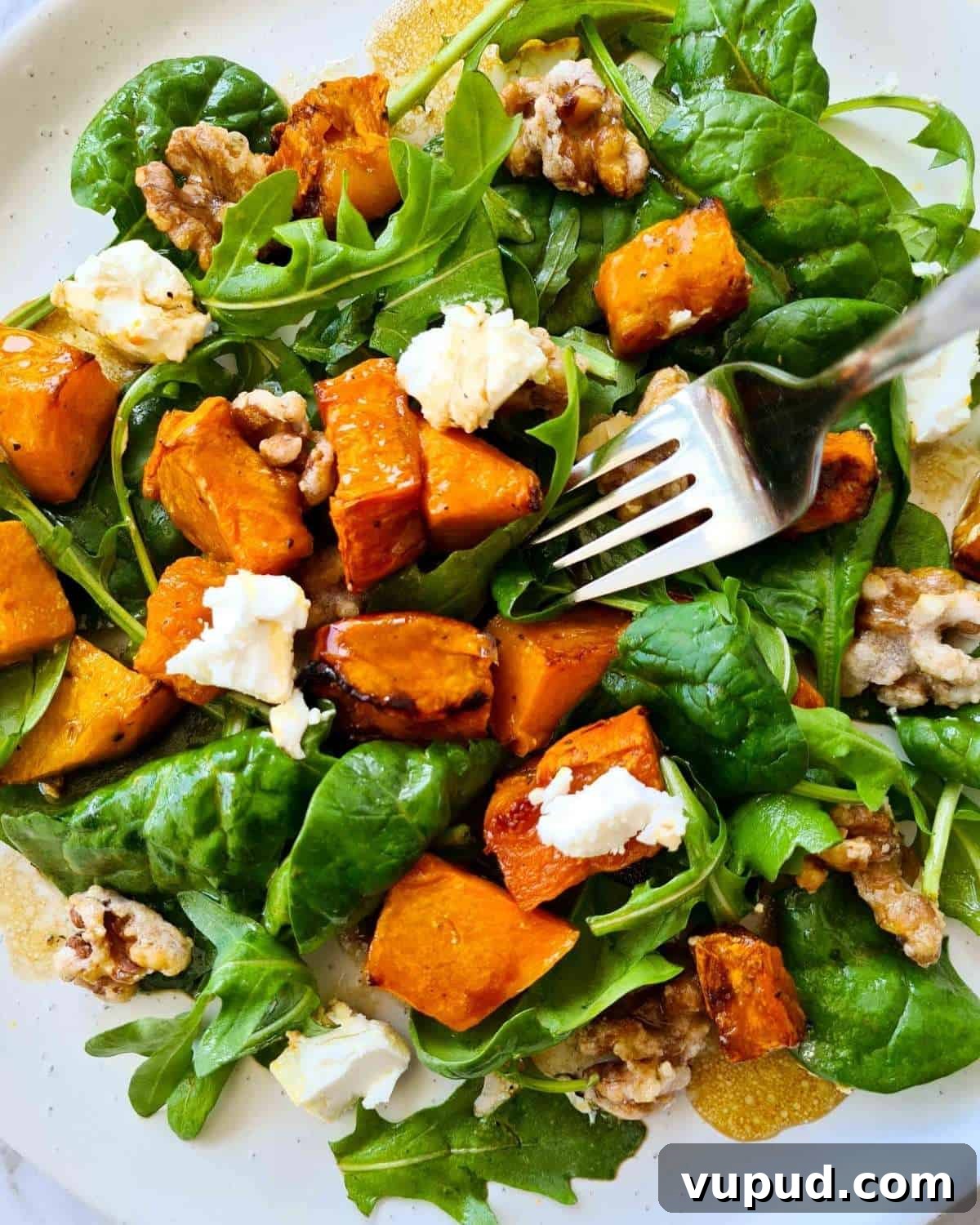 Roasted Pumpkin, Spinach & Goat Cheese Salad Rezept 2 Close up of a plate of pumpkin salad with a fork