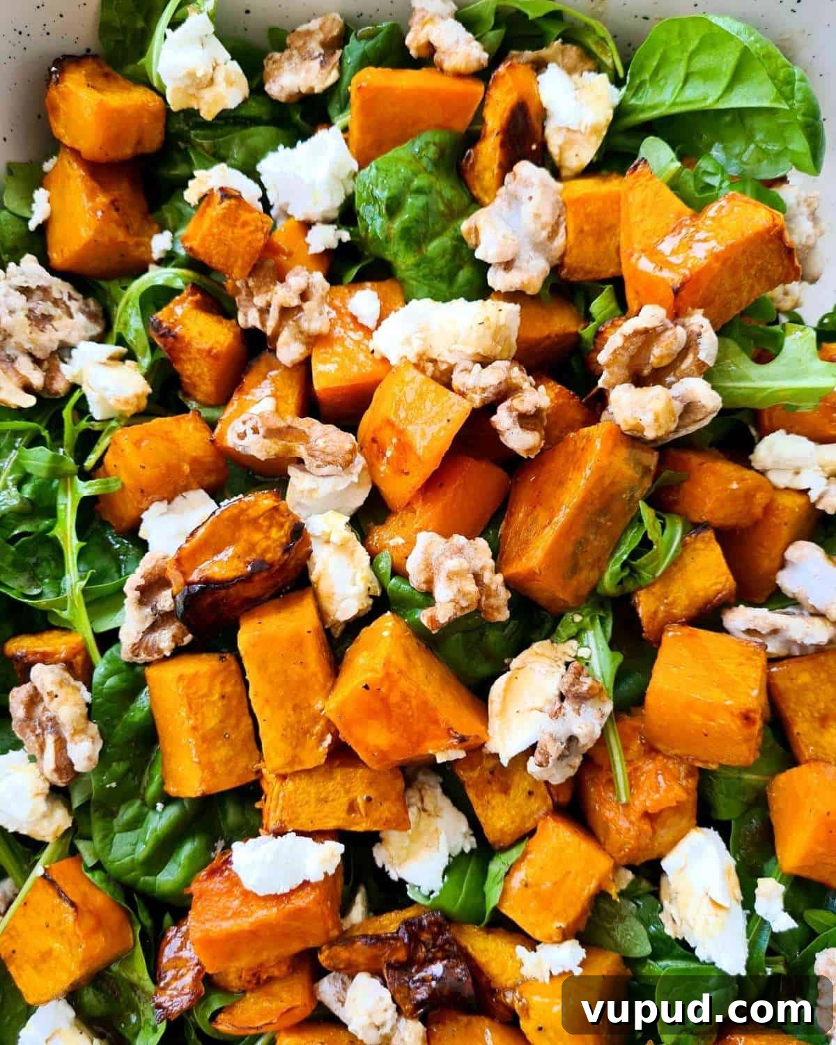 Roasted Pumpkin, Spinach & Goat Cheese Salad Rezept 6 Close up of a large serving dish of pumpkin salad with lots of walnuts and pumpkin
