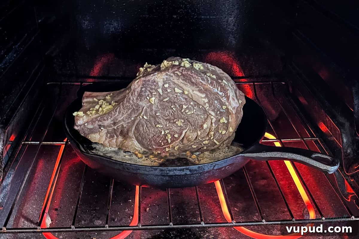 Perfectly Tender Sous Vide Prime Rib Roast Recipe 10 A rib roast standing in a cast iron skillet in a hot oven to sear.