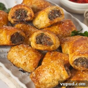 Mediterranean Beef Sausage Rolls with Herbed Feta and Spinach 16 White oval platter with Mediterranean Sausage Rolls, garnished with some parsley.
