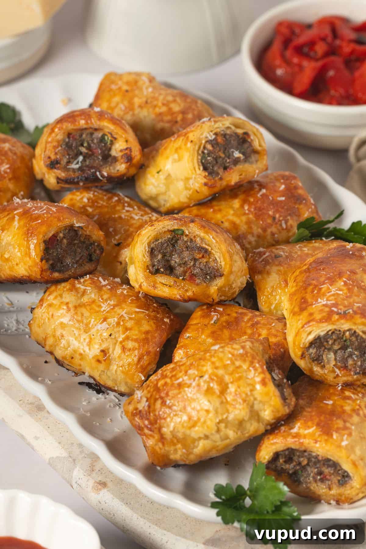 Mediterranean Beef Sausage Rolls with Herbed Feta and Spinach 5 White oval platter with Mediterranean Sausage Rolls, garnished with some parsley.