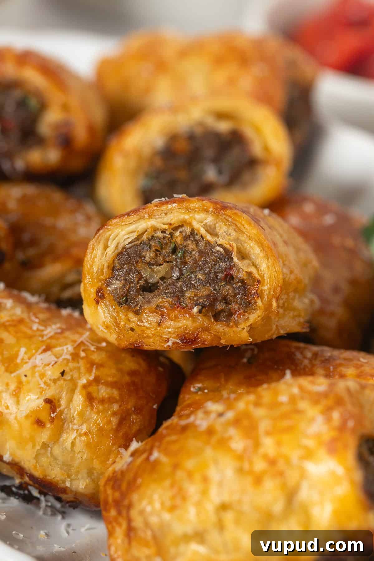 Mediterranean Beef Sausage Rolls with Herbed Feta and Spinach 9 Mediterranean Beef Sausage Rolls piled up on a white plate.