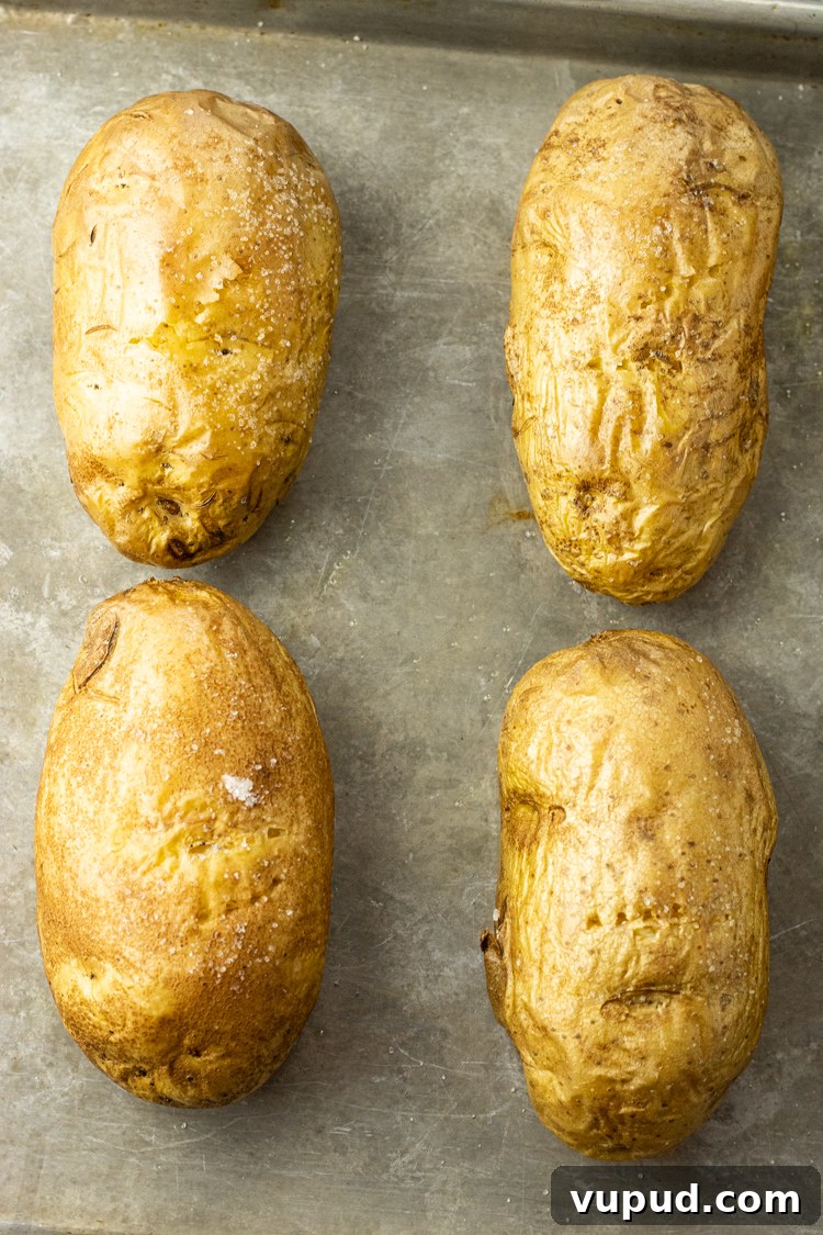 Crispy Oven-Roasted Potatoes with Garlic and Herbs 6 oven baked potatoes on a baking sheet