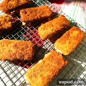 Crispy Homemade Mozzarella Sticks with Marinara Dipping Sauce 10 Golden mozzarella sticks on a wire rack.