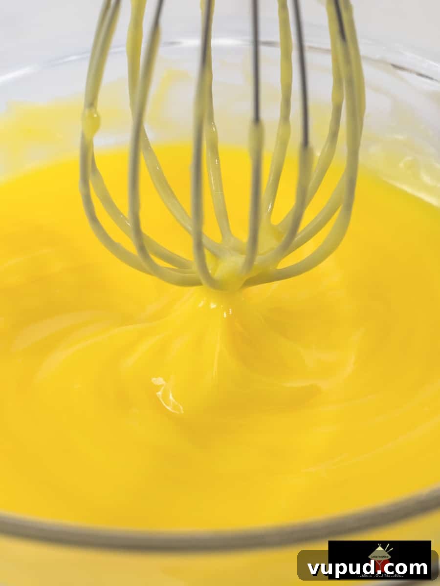 Creamy Homemade Lemon Curd Recipe for Smooth Citrus Spread 4 Whisking lemon curd over simmering water