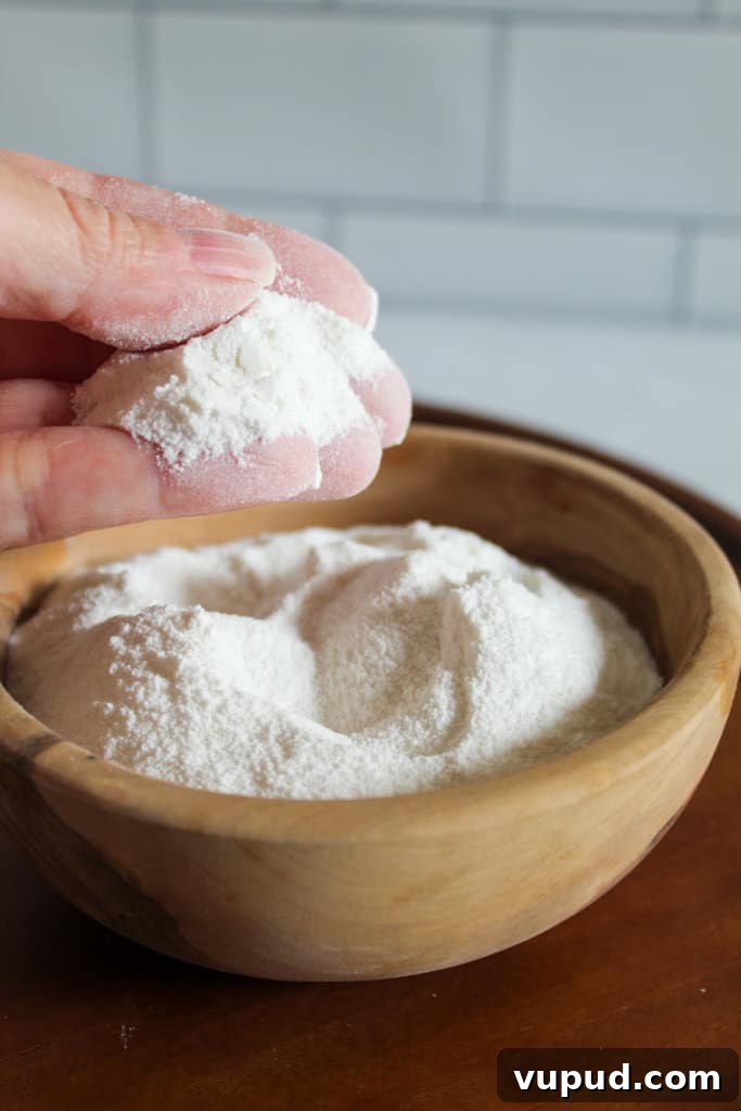 Soft & Fluffy Gluten-Free Hot Cross Buns: Simple Recipe for Spring 12 hand holding rice flour.