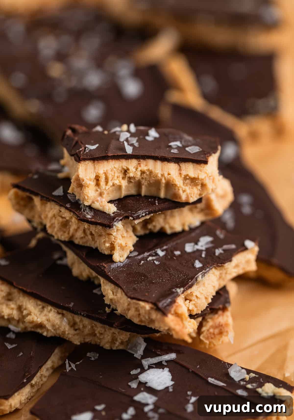 How to Make Creamy Greek Yogurt Bark with Fruit & Nuts 3 Greek yogurt bark with chocolate and sea salt stacked on each other with bite taken out of top piece.
