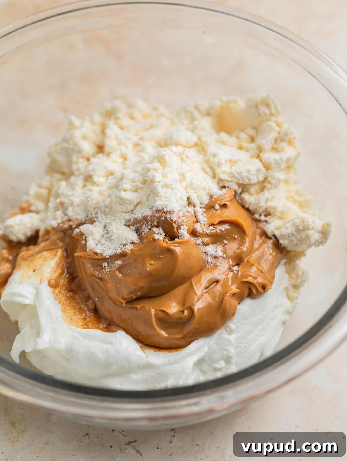 How to Make Creamy Greek Yogurt Bark with Fruit & Nuts 5 Peanut butter, plain Greek yogurt, protein powder and vanilla in glass mixing bowl.