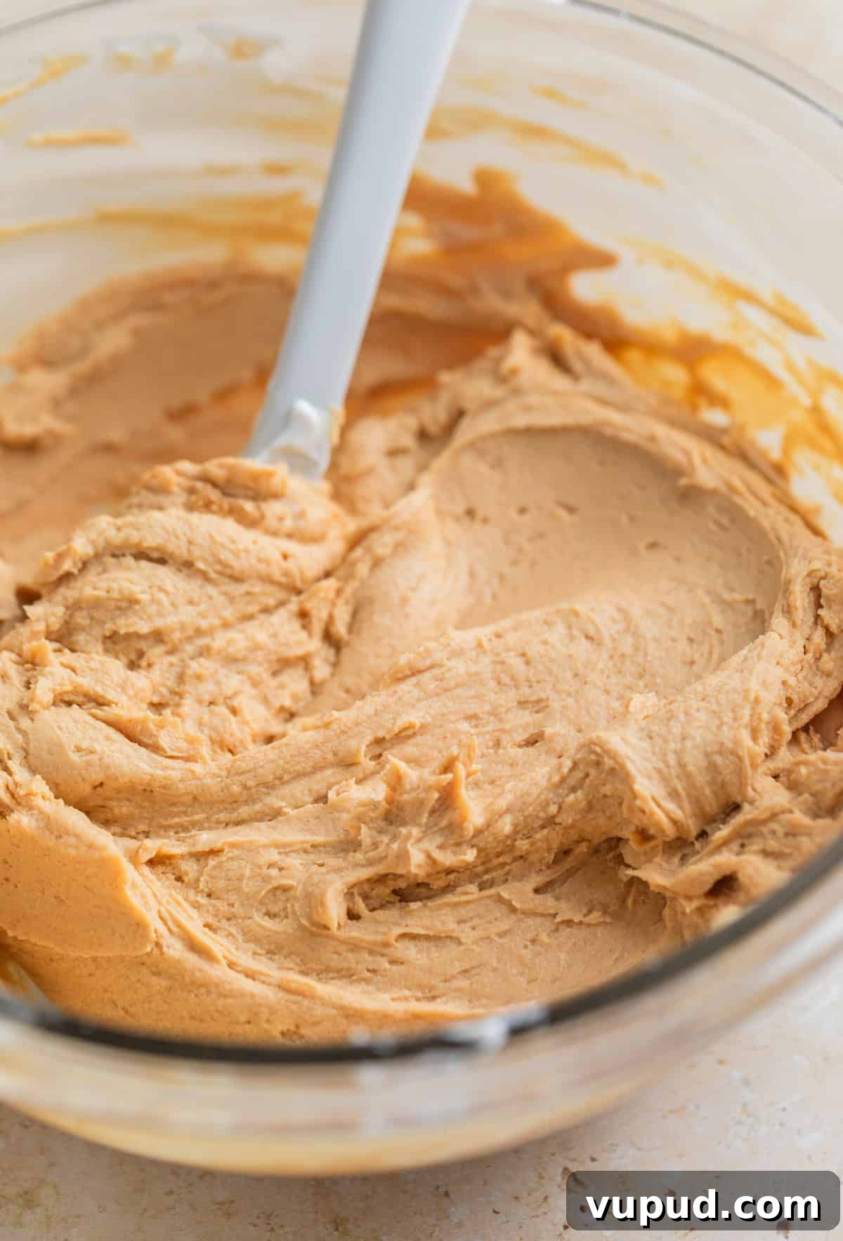 How to Make Creamy Greek Yogurt Bark with Fruit & Nuts 6 Peanut butter protein yogurt mixture in glass mixing bowl with spoon.