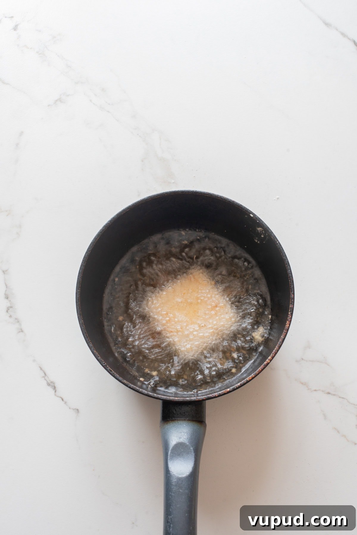 Crispy Tofu Katsu Recipe: Crunchy Plant-Based Cutlets 8 An overhead image of deep frying the breaded tofu.