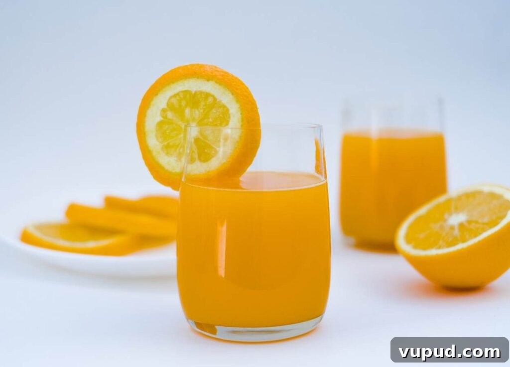 Glasses of orange juice on white background.