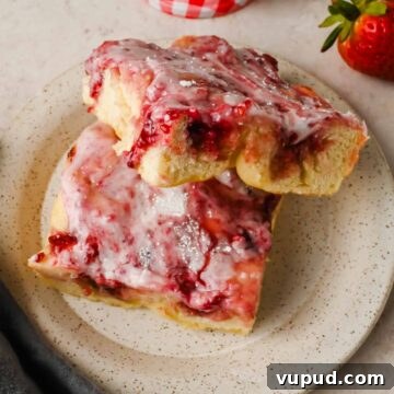 Raspberry Jam Sweet Focaccia Recipe for Soft, Fruity Bread 9 two slices of sweet focaccia with raspberry jam and powdered sugar glaze stacked on serving plate.