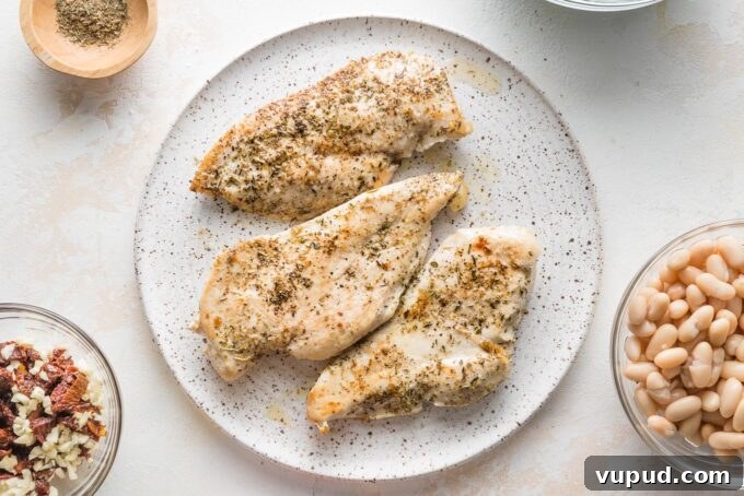 Tuscan Chicken with White Beans and Kale Recipe 4 Seared chicken breasts resting on a plate.