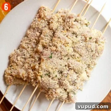 Crispy Chicken Spiedini Skewers with Lemon Herb Marinade 9 Breaded chicken skewers on a plate.