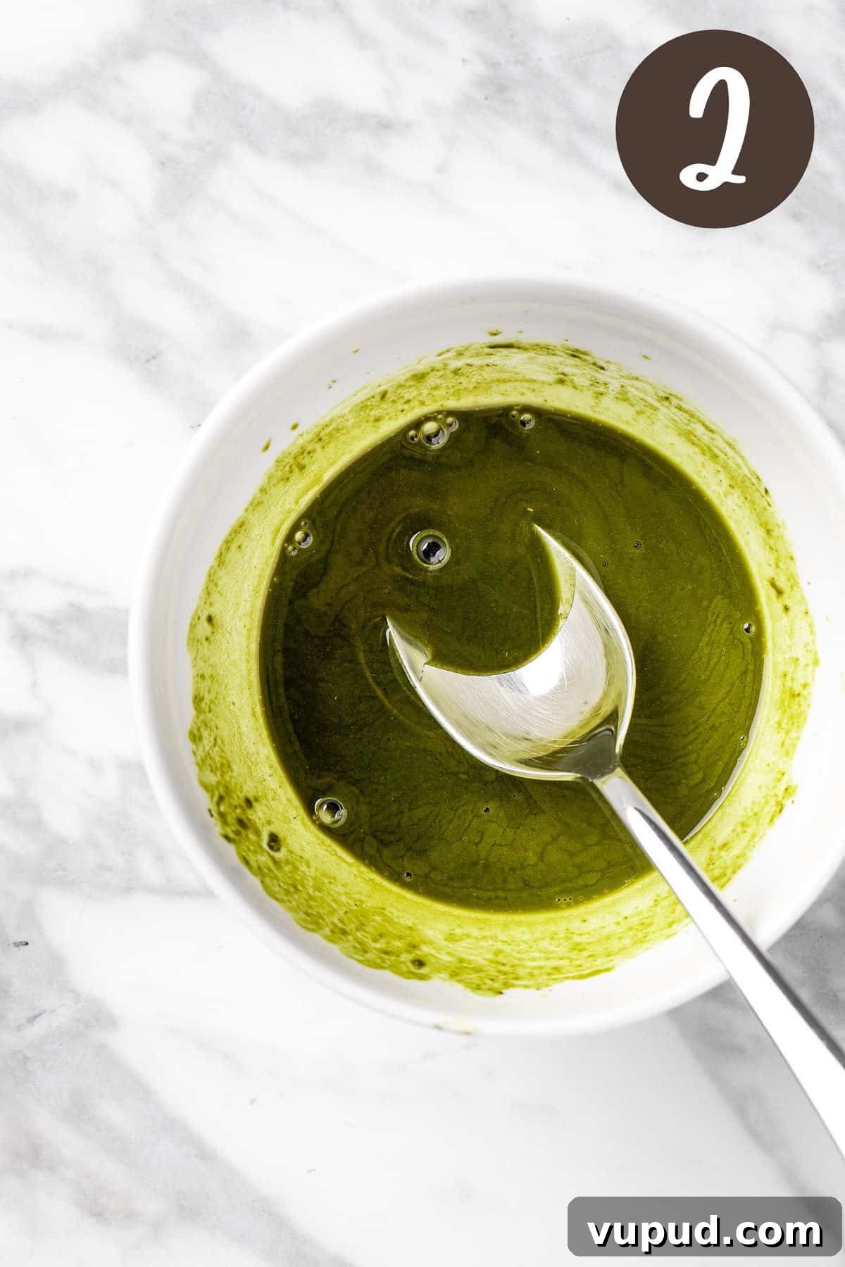 Creamy Oat Milk Matcha Latte Recipe for Perfectly Frothy Mornings 5 A process photo illustrating step 2: mixing the maple syrup and honey into the matcha.