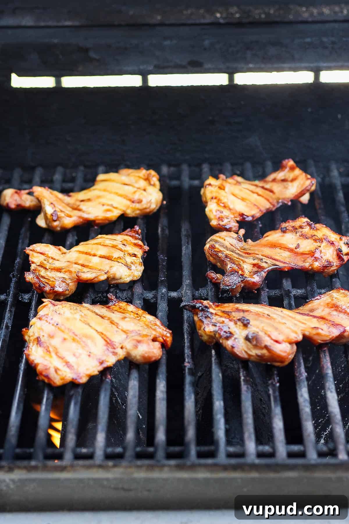 Sticky Grilled Teriyaki Chicken Recipe with Charred Scallions 4 Chicken thighs cooking on a gas grill.