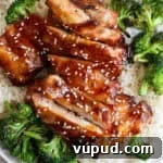 Sticky Grilled Teriyaki Chicken Recipe with Charred Scallions 10 A plate of rice topped with grilled broccoli and grilled teriyaki chicken with sesame seeds on top.