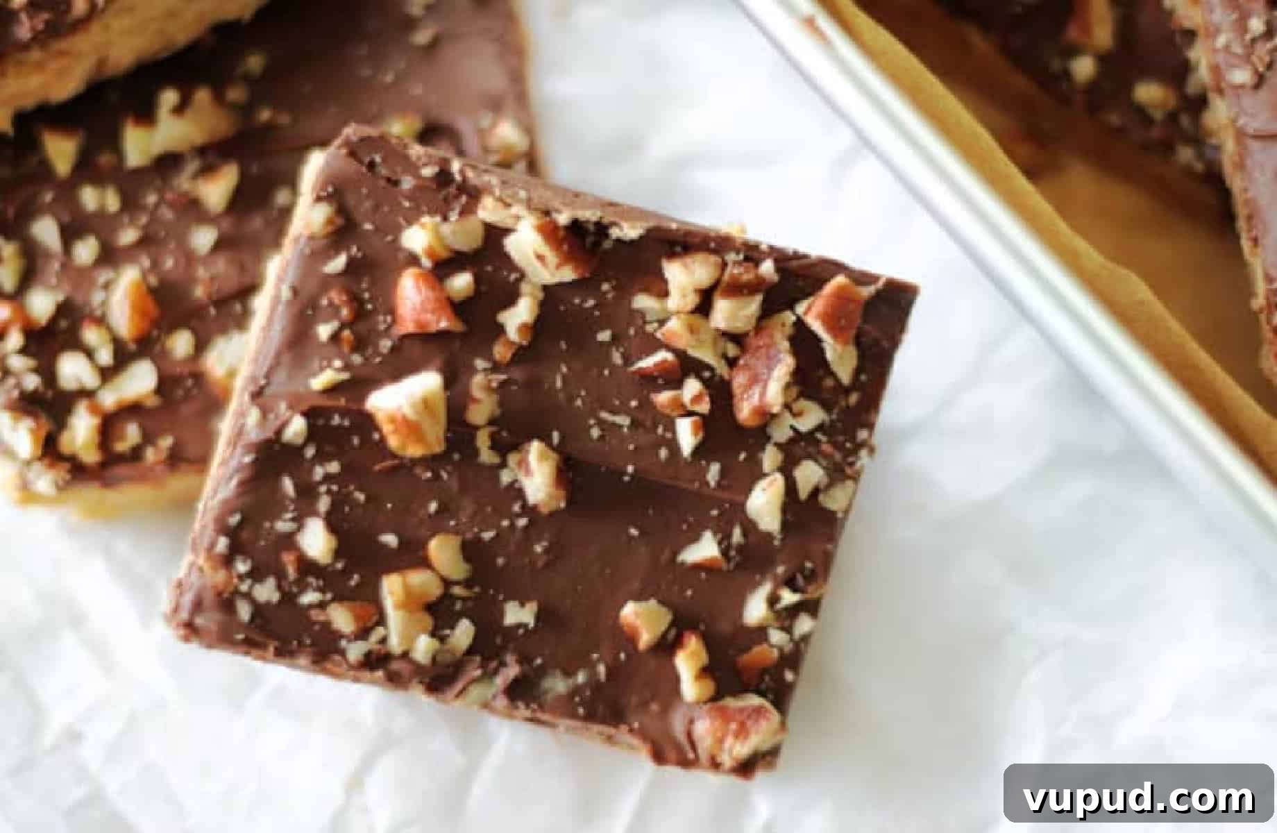 Classic Chewy Toffee Bars Recipe with Buttery Shortbread 2 Two toffee bar squares cut and set on parchment paper.