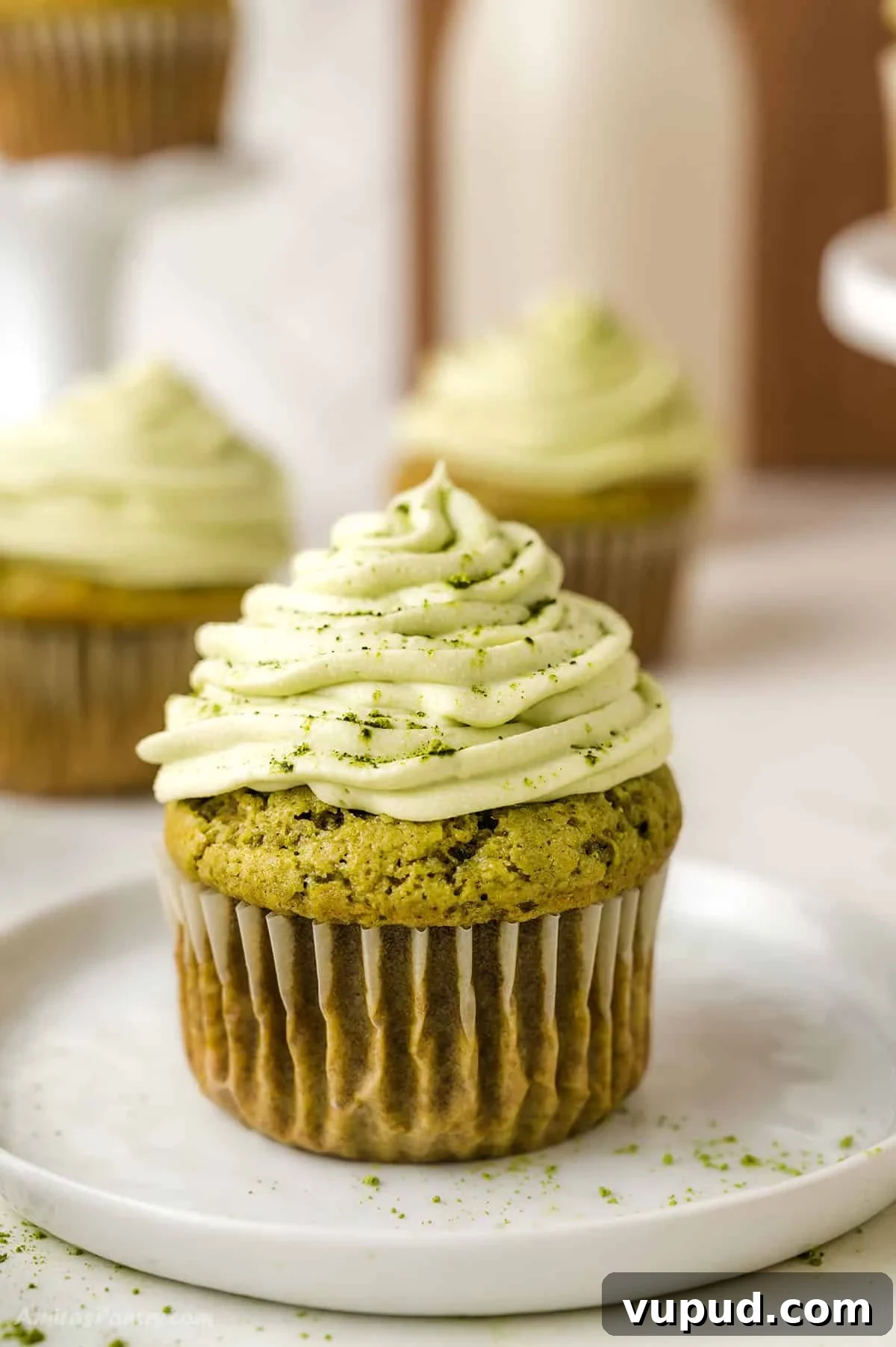 Matcha Cupcakes Recipe: Moist Green Tea Cupcakes with Frosting 2 One matcha cupcake on a white dessert table.