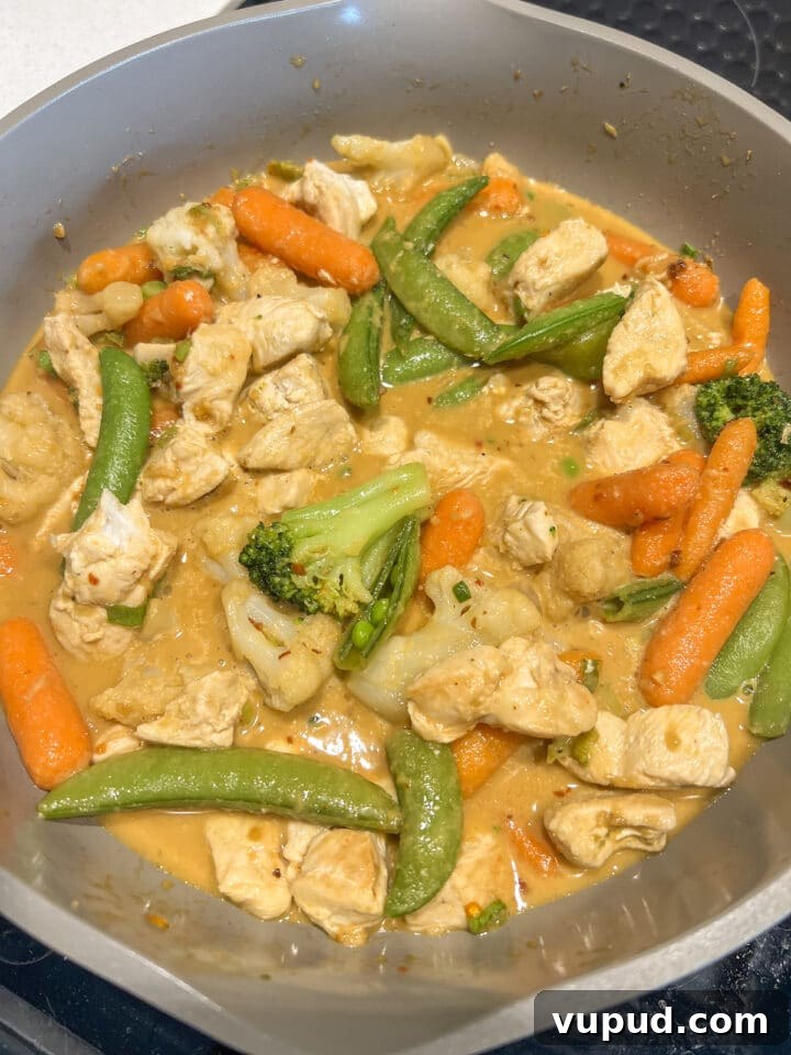 Sesame Garlic Stir-Fry with Frozen Vegetables 7 Vegetables and cubed chicken in a large non-stick pan with sesame garlic stir fry sauce