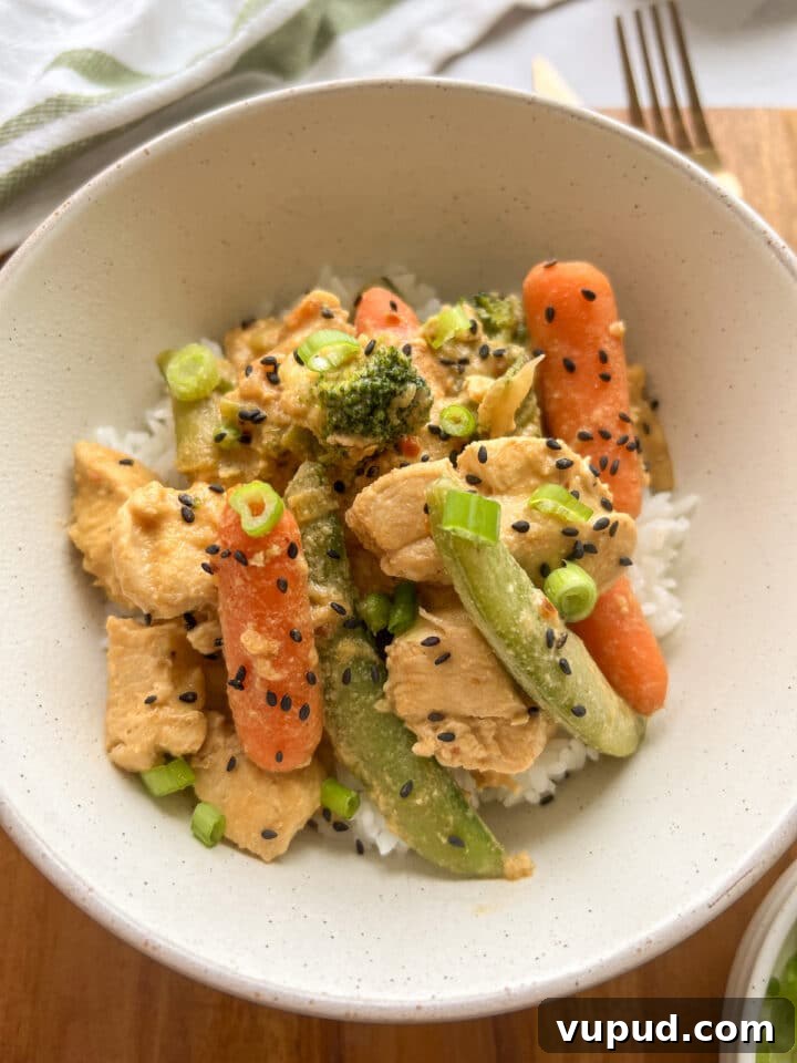 Sesame Garlic Stir-Fry with Frozen Vegetables 8 Close-up photo of frozen vegetable stir fry in a small white bowl, served over rice