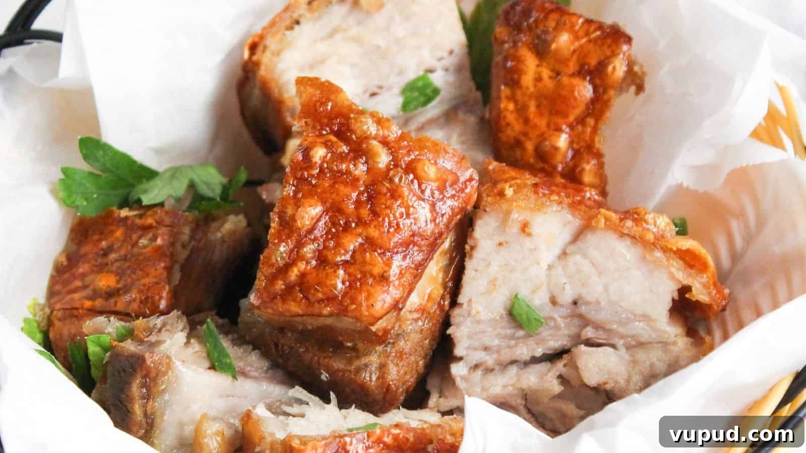 30 Flavorful Low-Carb Main Dishes That Feel Like Real Meals 12 A basket of crispy roasted pork belly chunks garnished with parsley, served in a white paper-lined wicker basket.