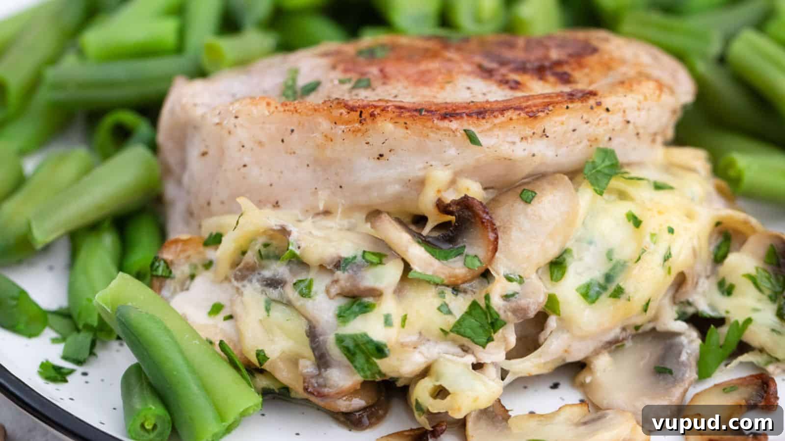 30 Flavorful Low-Carb Main Dishes That Feel Like Real Meals 18 A plate of pork chops stuffed with mushrooms and cheese served with green beans.