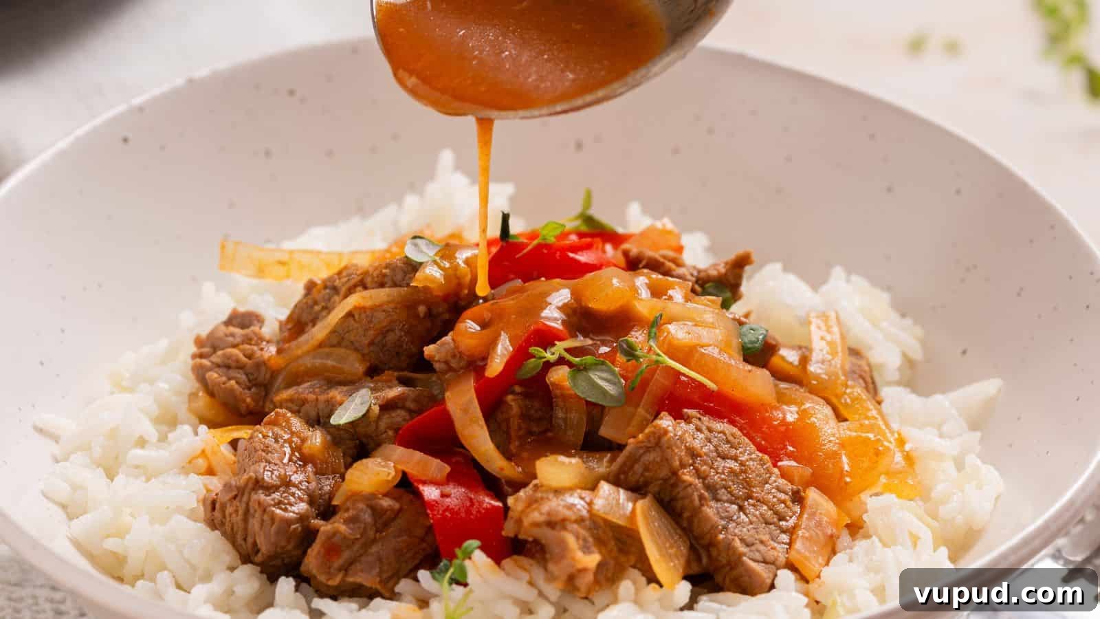 30 Flavorful Low-Carb Main Dishes That Feel Like Real Meals 20 Pouring savory sauce over a bowl of rice topped with beef and bell peppers.