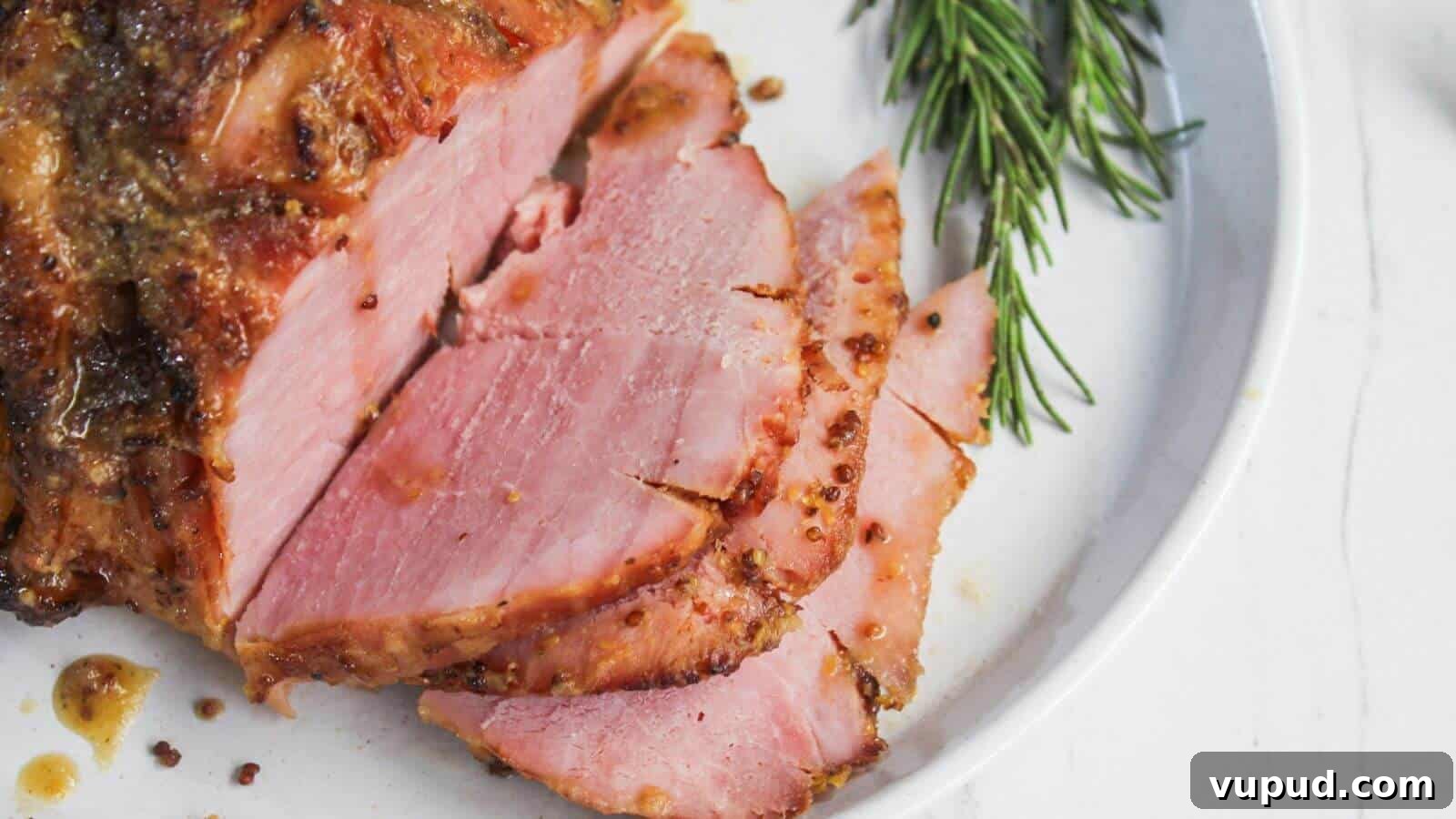 30 Flavorful Low-Carb Main Dishes That Feel Like Real Meals 21 Sliced roasted ham garnished with sprigs of rosemary on a white plate.