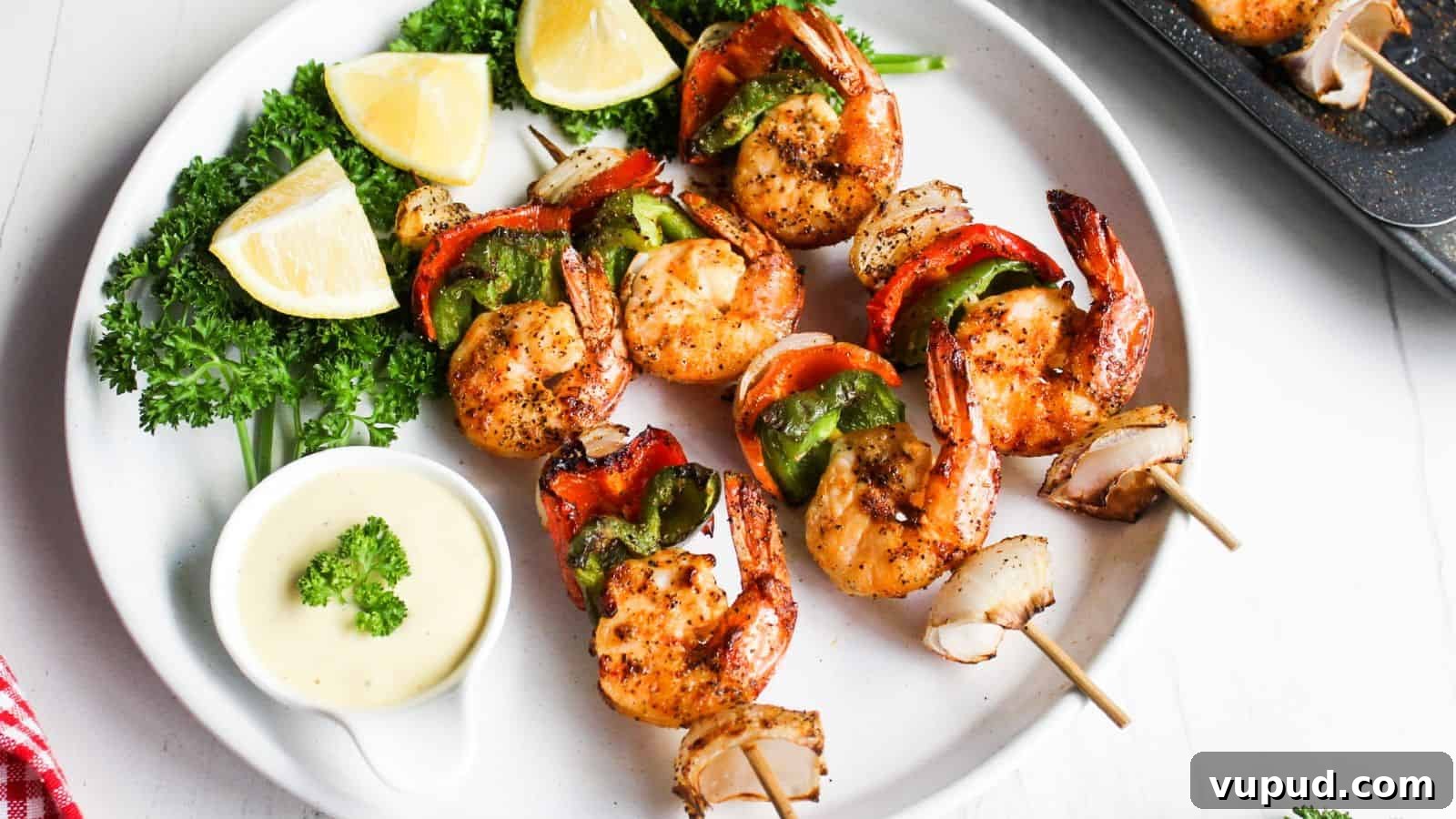 30 Flavorful Low-Carb Main Dishes That Feel Like Real Meals 22 Grilled shrimp skewers with red and green bell peppers, served with lemon wedges and a dipping sauce on a white plate.