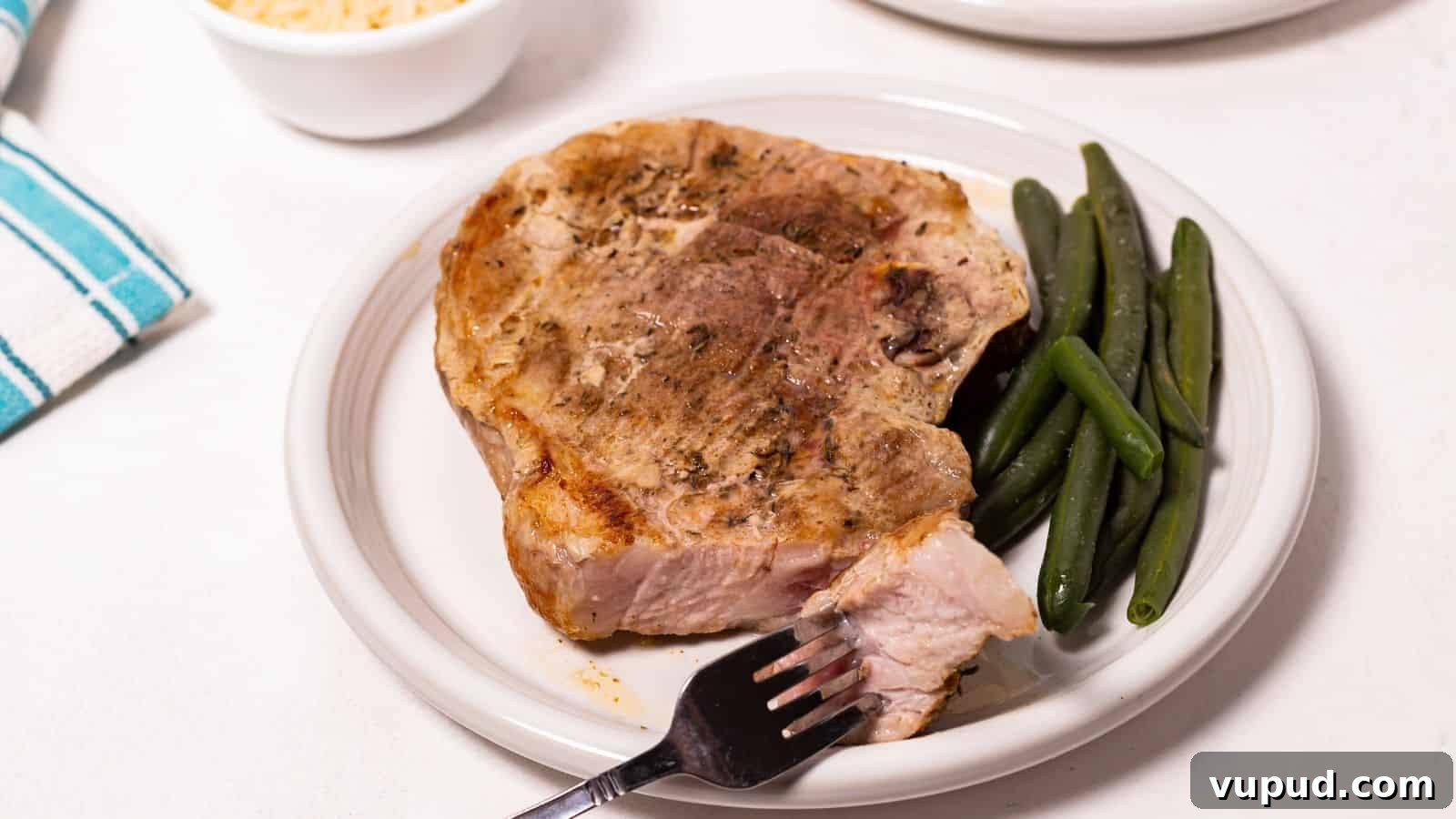30 Flavorful Low-Carb Main Dishes That Feel Like Real Meals 23 Oven baked pork steak on a plate with green beans and a fork on the side.