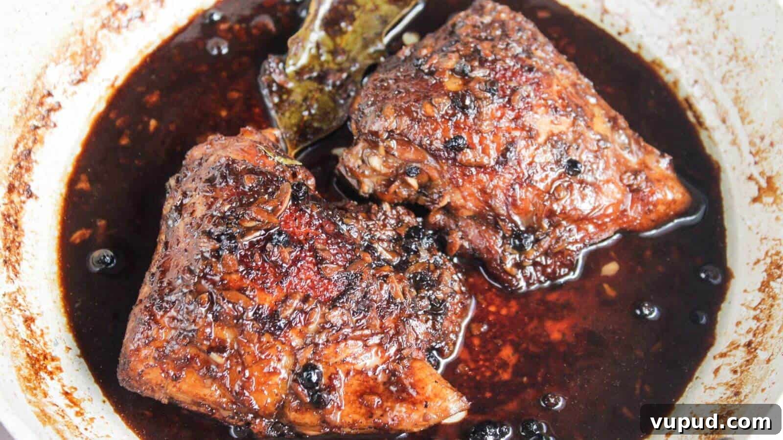 30 Flavorful Low-Carb Main Dishes That Feel Like Real Meals 6 Two pieces of braised meat in a dark, rich sauce, seasoned with whole peppercorns and a bay leaf, in a pan.