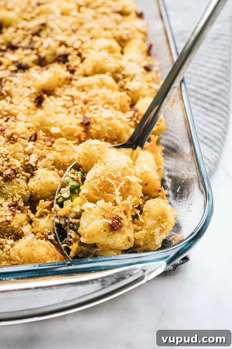 Cheesy Tater Tot Casserole Recipe for Family Dinners 3 a spoon removing a serving of tater tot casserole from the dish