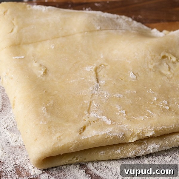 How to Blind-Bake a Pie Crust for a Perfect Fill 4 Folding rolled out pie crust pastry before placing it in a pie plate to bake.