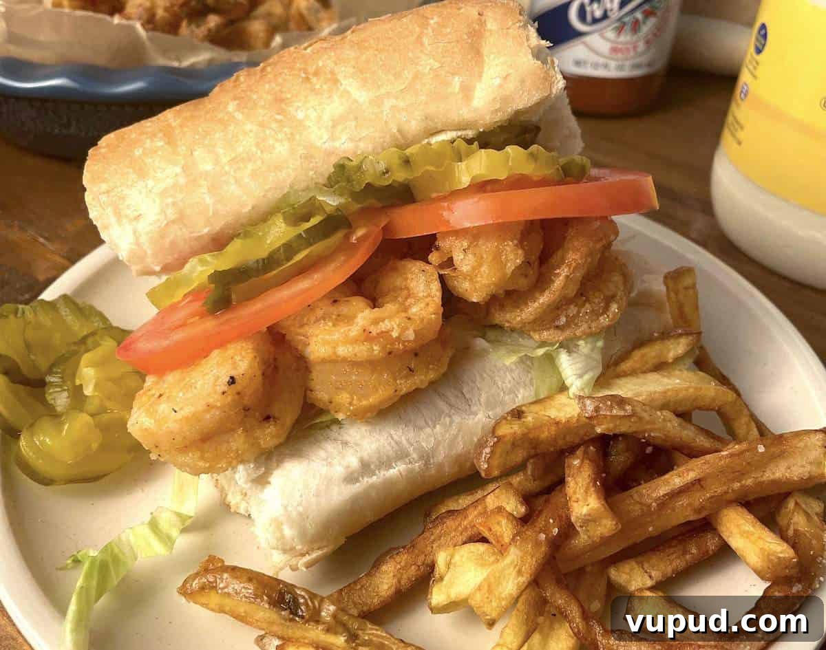 Crispy Fried Shrimp Po' Boy Sandwich Recipe 3 A fried shrimp po boy sandwich with extra pickles and crispy fries.