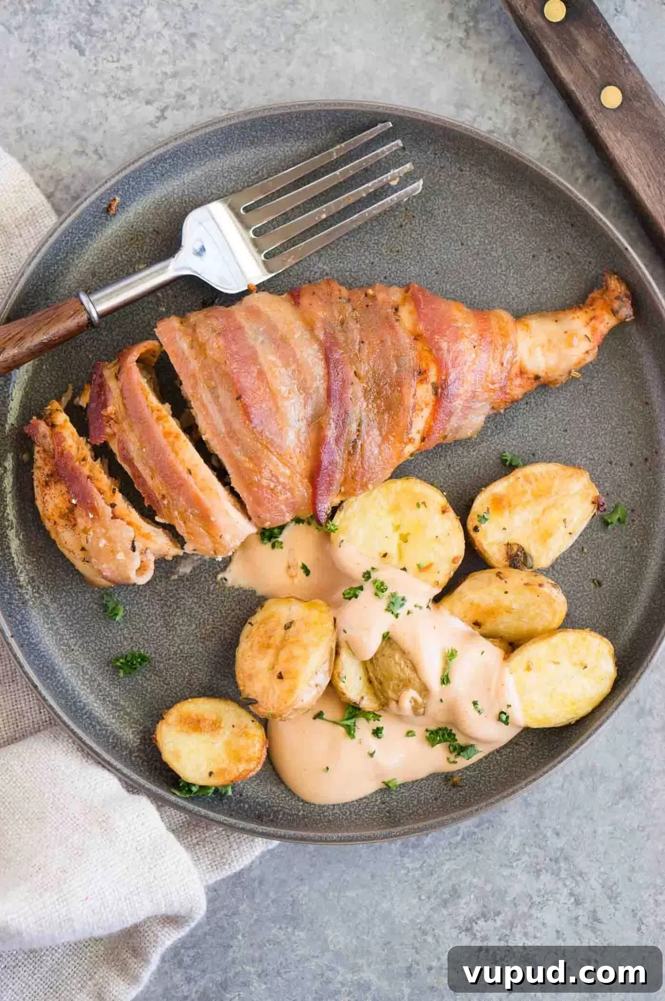 Crispy Bacon-Wrapped Chicken Breasts with Garlic Herb Glaze 2 bacon wrapped chicken served with roasted potatoes