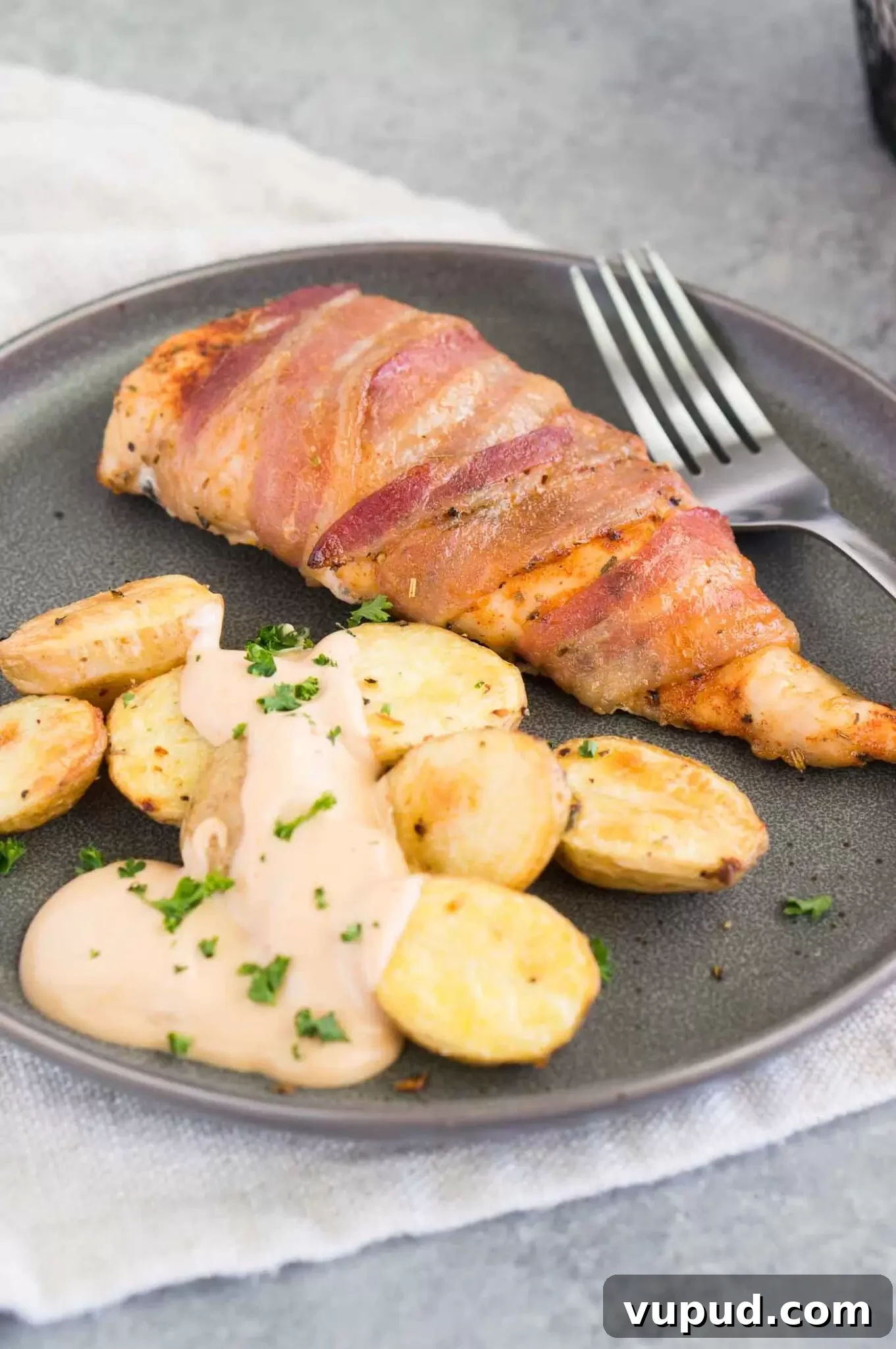Crispy Bacon-Wrapped Chicken Breasts with Garlic Herb Glaze 8 chicken breasts with bacon on a plate with potatoes