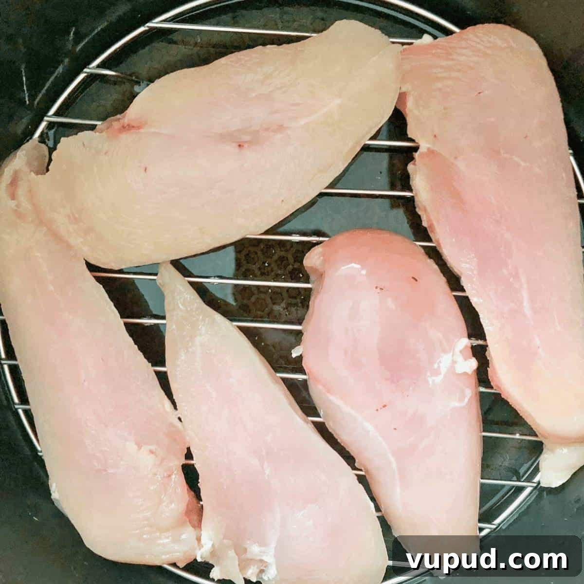 Frozen chicken breasts placed on the trivet in the pressure cooker.