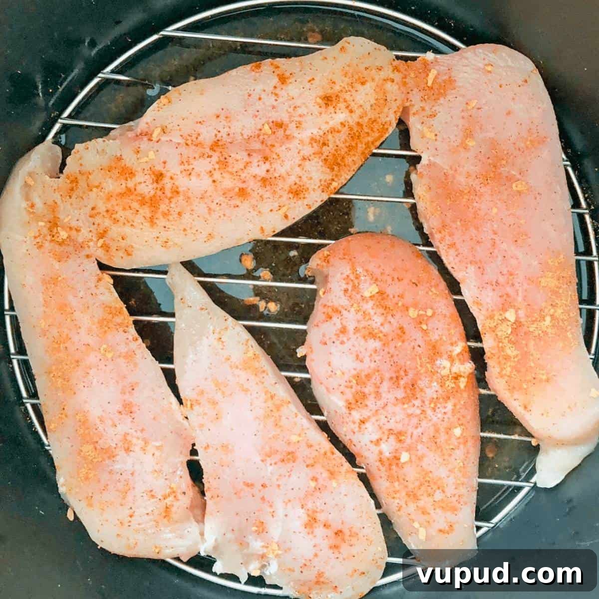 Frozen chicken breasts sprinkled with seasoning in the Instant Pot.